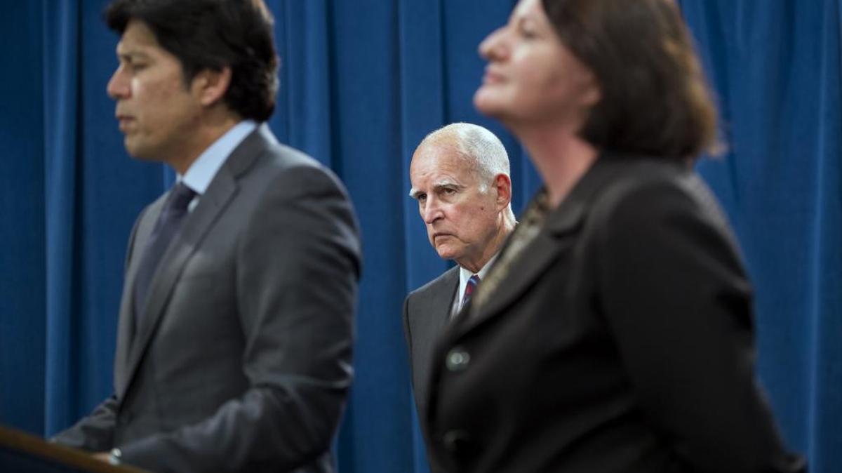 
Gov. Jerry Brown, center, listens Wednesday to Senate President Pro Tem Kevin de León, left, and Assembly Speaker Toni Atkins as they announce they will abandon efforts this year to require a 50 percent reduction in petroleum use in motor vehicles by 2030.

