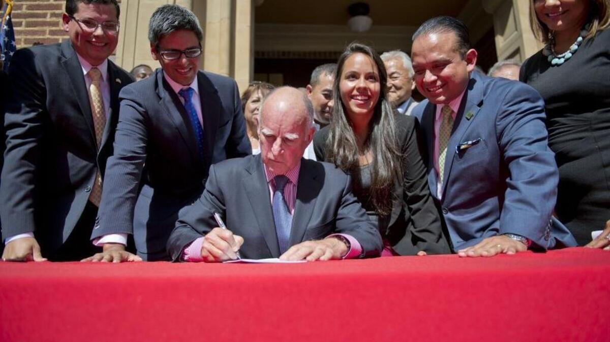 Gov. Jerry Brown signs a driver's license bill for undocumented immigrants at Fresno City College in on October 3, 2013.