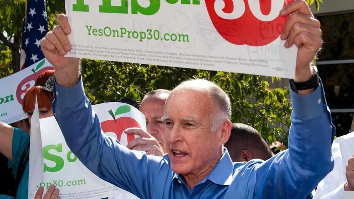 
Students, dignitaries and supporters cheer on Gov. Jerry Brown as he holds a campaign sign and encourages students to vote for Proposition 30 at Sacramento City College in October 2012. 
