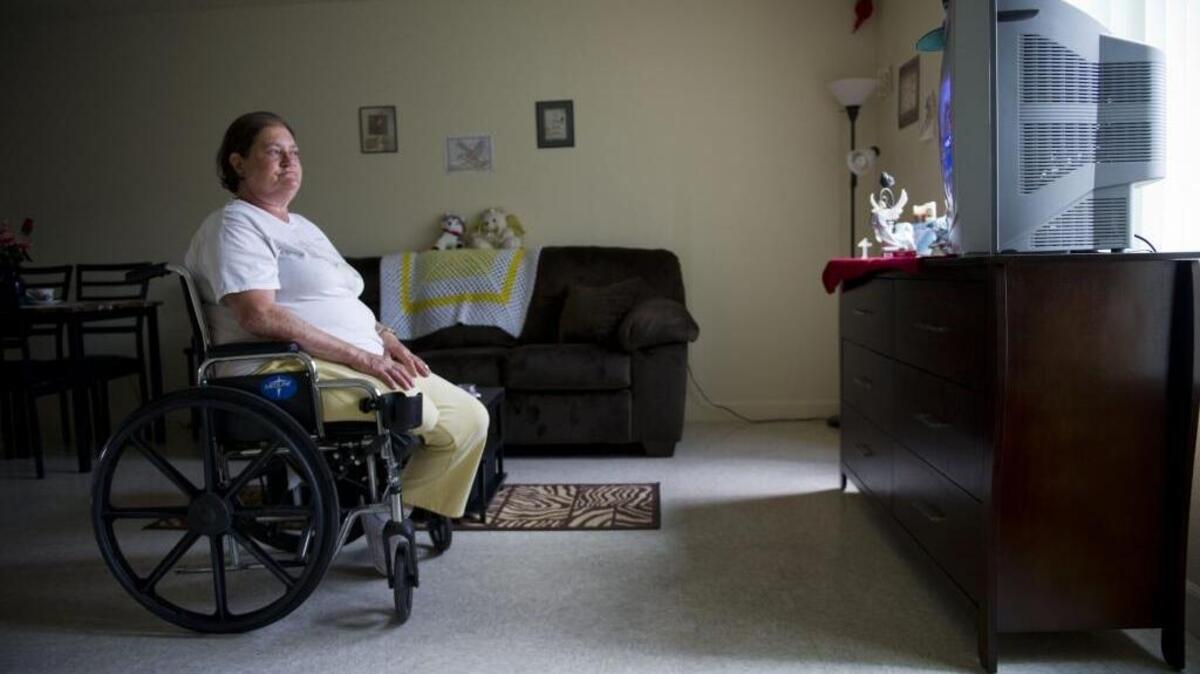 Cheryl McGuire watches a television show in her South Sacramento apartment apartment for low-income, disabled adults on May 14, 2015.