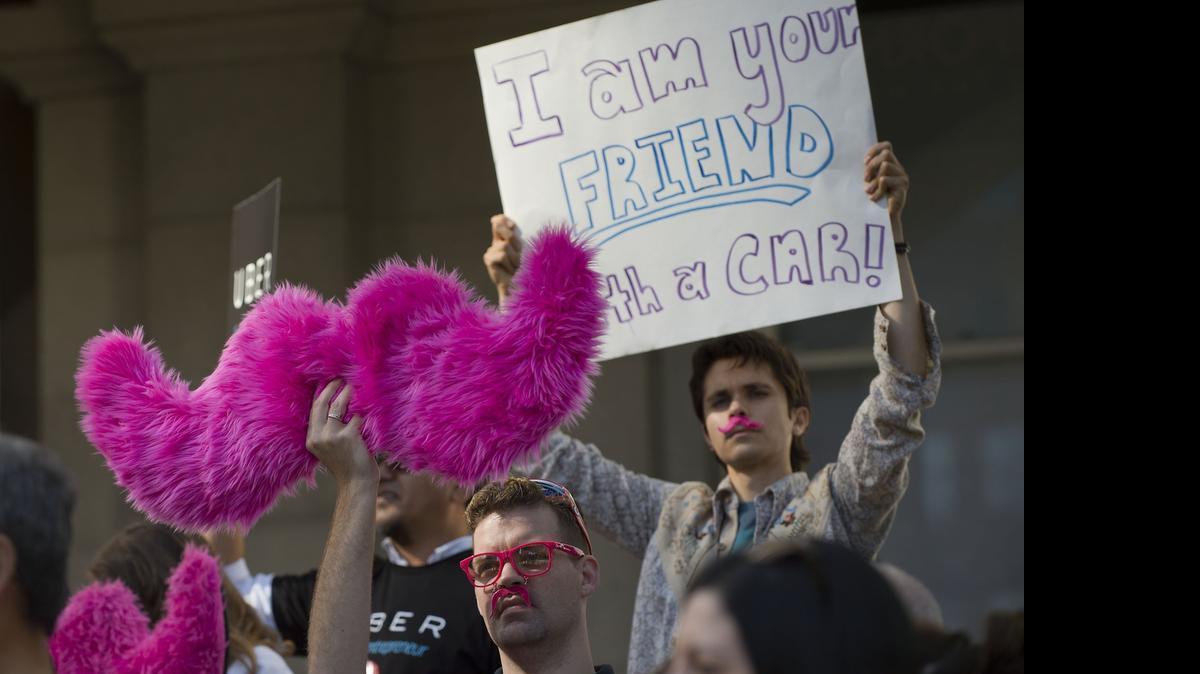 
Opponents to ridesharing bills hold signs during a rally at the state Capitol in Sacramento in 2014. Legislation allowing California commuters to carpool using services like Uber and Lyft could be finished for the year after a committee hit the brakes ahead of an approaching deadline.


