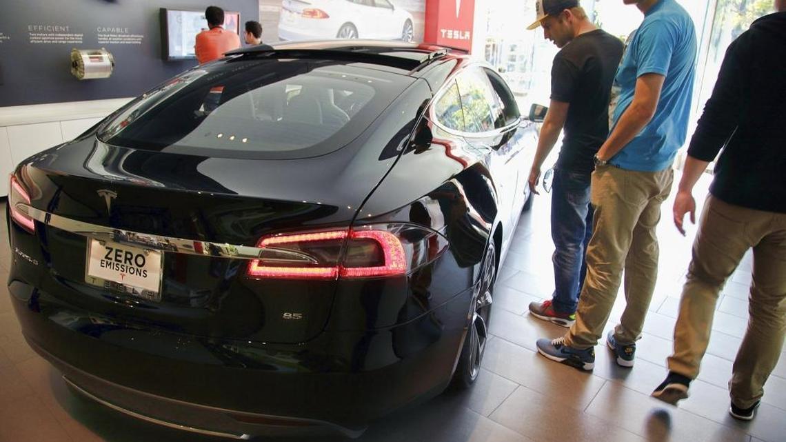 People check out the Model S at the Tesla showroom on the Third Street Promenade in Santa Monica on Jan. 3, 2015.