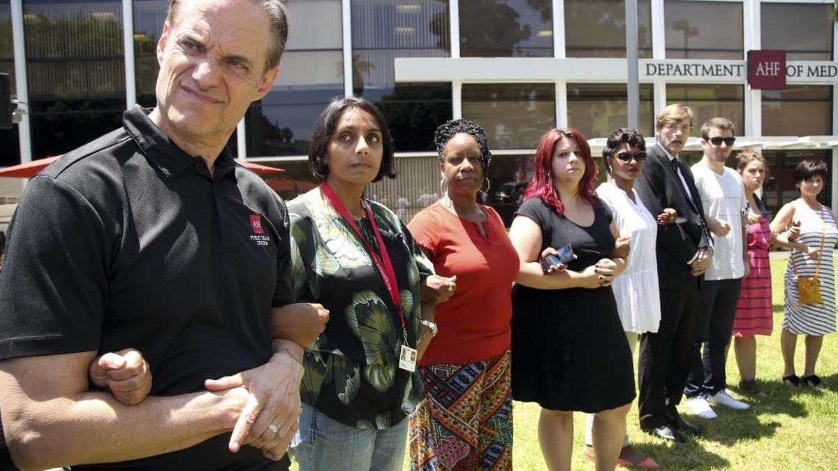 Michael Weinstein, left, president of AIDS Healthcare Foundation in Los Angeles, locks arms with others at a 2014 memorial for people headed to an AIDS conference who were on the Malaysia Airlines flight shot down over Ukraine.