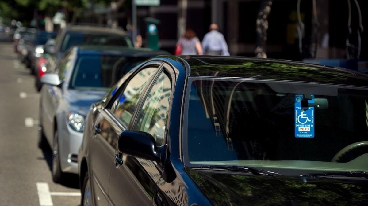 A disabled parking placard is displayed in a car window parked on J Street in downtown Sacramento.