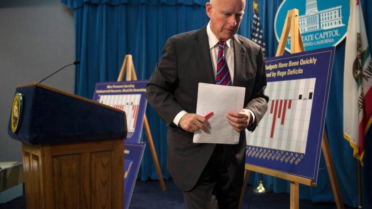 Gov. Jerry Brown carries notebook paper outlining his proposed 2016-17 state budget after a news conference at the California State Capitol Thursday, Jan. 7, 2016, in Sacramento, Calif. Brown’s plan includes billions of dollars in new funding for schools, climate change programs and services for the elderly and disabled.