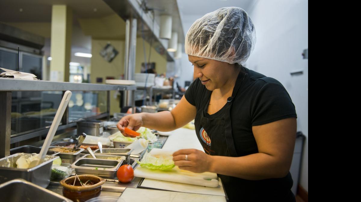 
Guadalupe Solis prepares a sandwich while working as a line cook at Plates Cafe and Catering, an employment training program for homeless mothers offered by St. John's Shelter.
