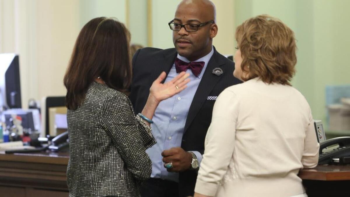 
Then-Assemblyman Isadore Hall, D-Compton, talks with GOP Assembly members Diane Harkey, of Dana Point, left, and Shannon Grove, of Bakersfield, after the Assembly approved his smoking bill banning smoking in home day care centers, in 2014. Hall, now a senator, is running for Congress.
