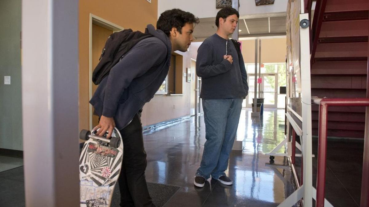 Alexander Ravera and Patric Brazier look at a class list at American River College in 2013.