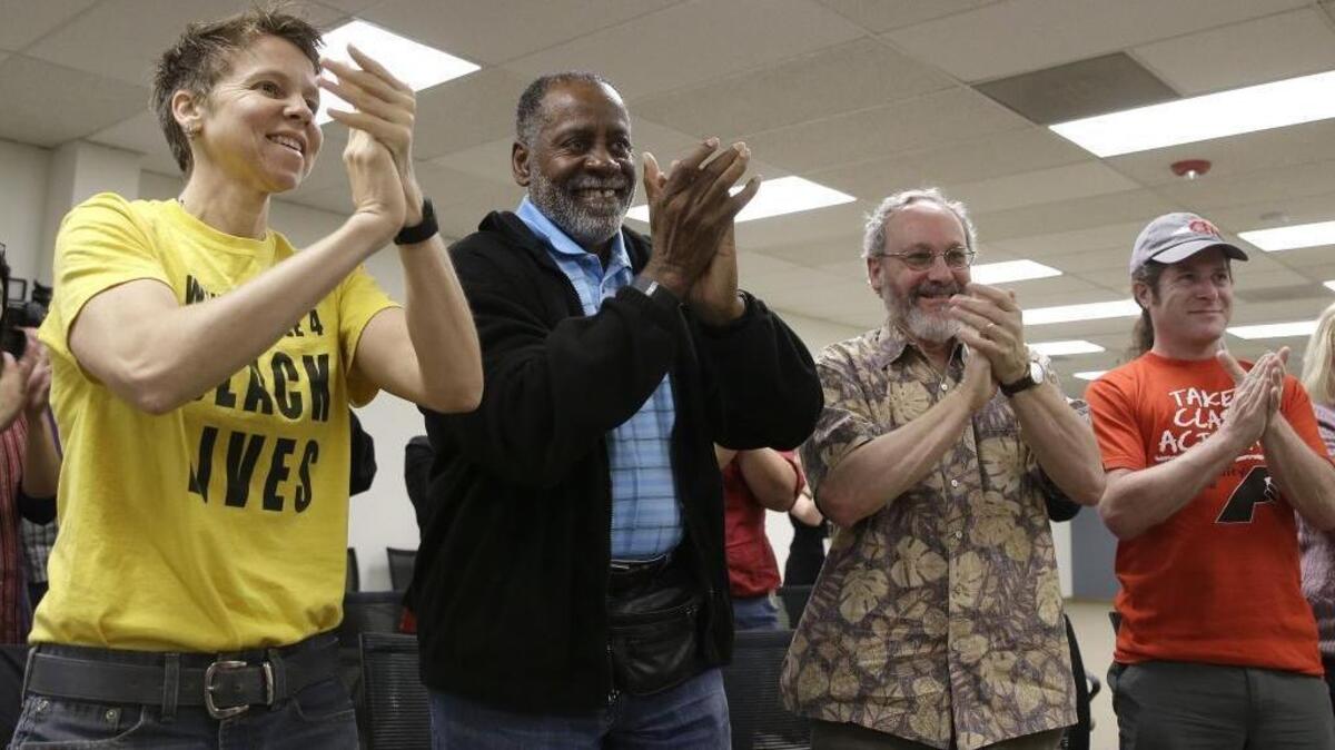 California Faculty Association members Molly Talcott, Cecil Canton, Jonathan Karpf and Mark Karplus applaud after a news conference to discuss the tentative contract agreement between California State University and its teaching staff on April 8, 2016.