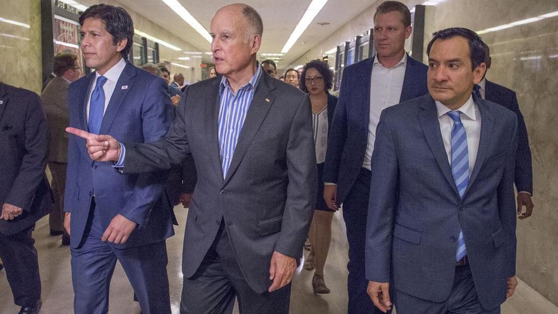 Gov. Jerry Brown, center, leads legislators with Senate Pro Tem Kevin de Leon, D-Los Angeles, and Assembly Speaker Anthony Rendon, D-Paramount, after they passed climate change legislation on Monday.
