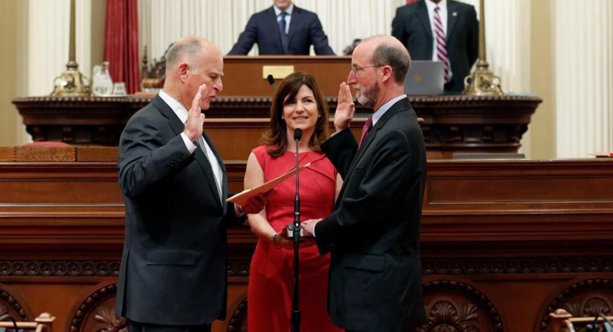 
Gov. Jerry Brown, left, on May 28, 2015 delivers the oath of office to his former campaign strategist, Steven Glazer, an Orinda Democrat who won a special election for state Senate.Holding the Torah is Glazer’s wife, Melba Muscarolas.

