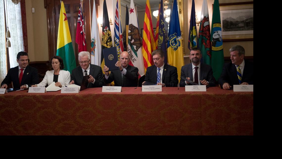 
Gov. Jerry Brown, center, is the first to sign and hold up his document after announcing a climate change agreement with government leaders from around the world at the Leland Stanford Mansion on Tues., May 19, 2015 in Sacramento, Calif. From left to right are Jalisco Governor Aristoteles Sandoval, Magaly Medeiros, Director-President of the Regulatory Department of Environmental Services at the Institute for Climate Change, Baden-Wurttemberg Minister-President Winfried Kretschmann, State of Baja California Governor Francisco Vega de Lamadrid, Catalonia Minister of Territory and Sustainability Santi Vila, and Ontario Minister of Environment and Climate Change Glen Murray.
