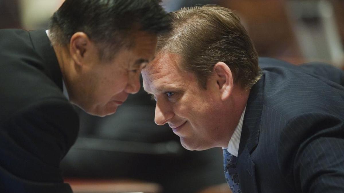 Then-state Sens. Leland Yee, left, and Tony Strickland chat in private as the California Senate considers high-speed rail funding on July 6, 2012.