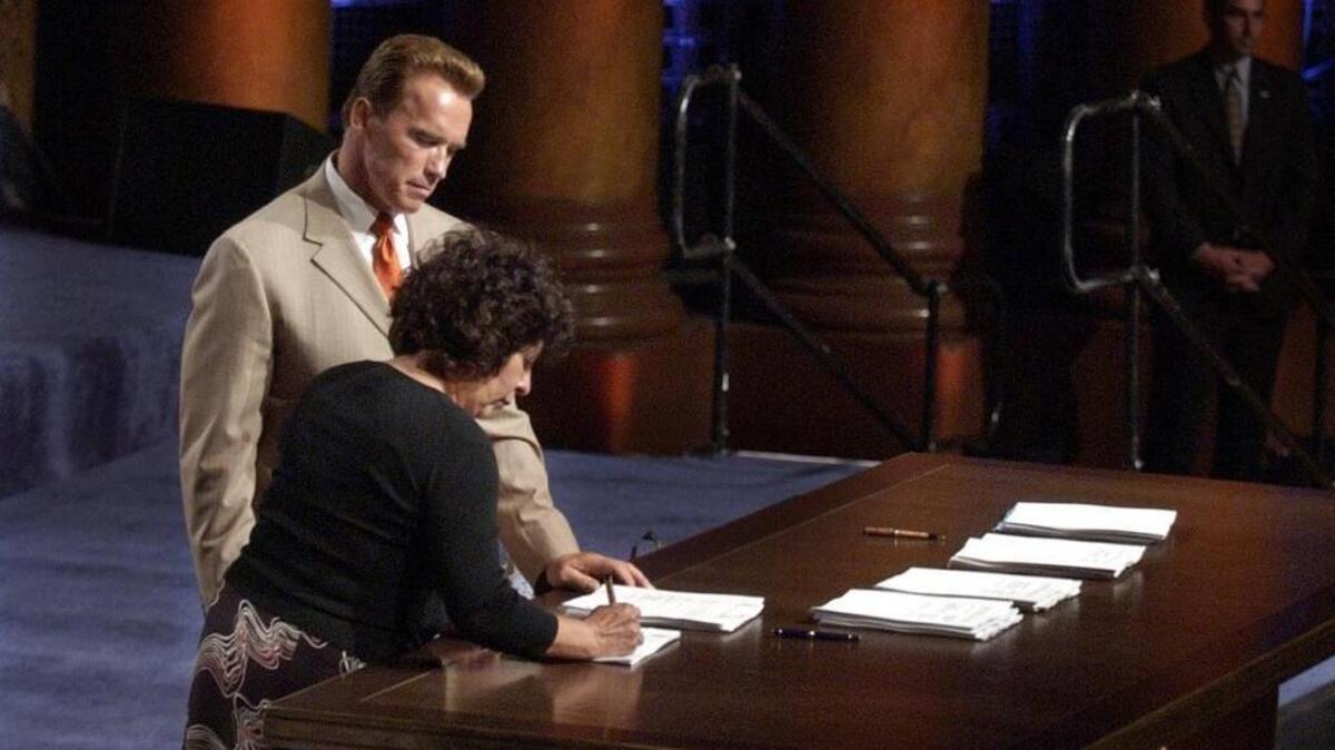 
In 2004, Gov. Arnold Schwarzenegger watches as Jessica Tavares, of the United Auburn Indian Community, signs the last of five renegotiated gambling compacts during a ceremony at Memorial Auditorium in Sacramento. Gov. Jerry Brown and the tribe have signed an amended deal awaiting legislative ratification.
