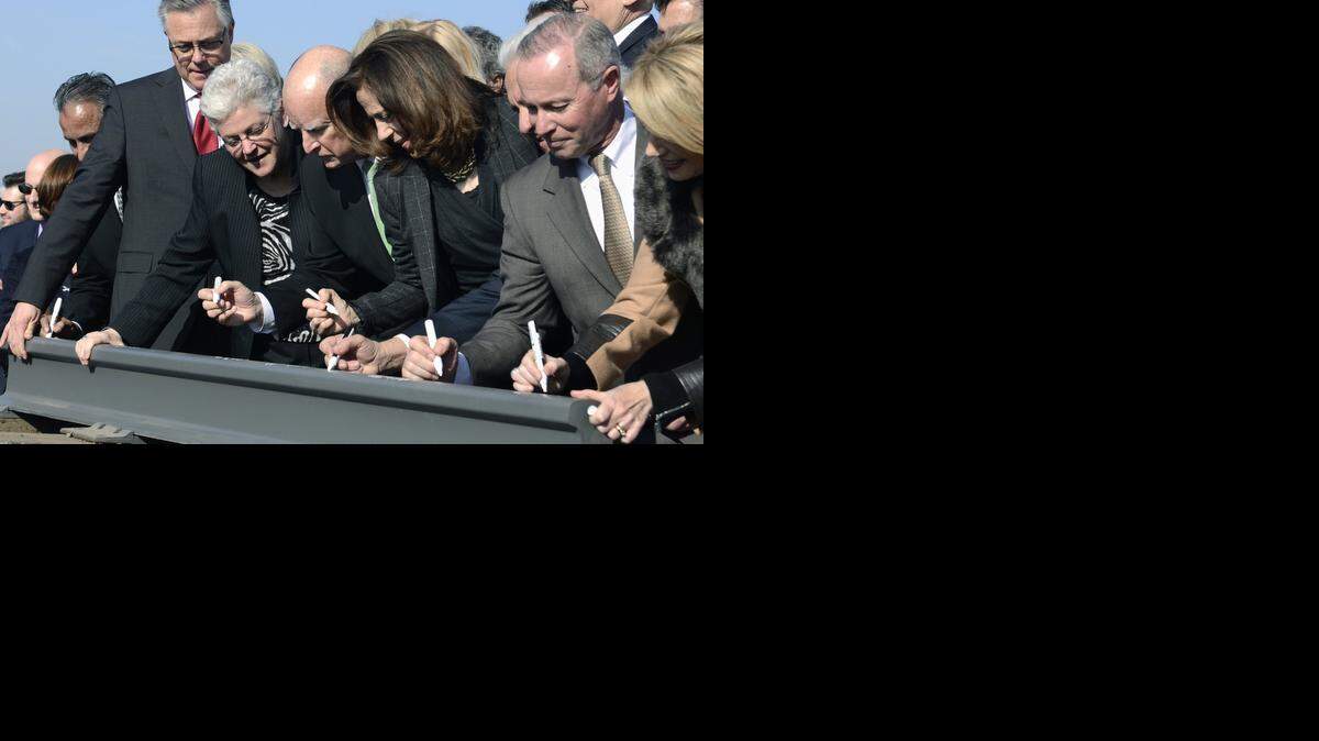 Governor Jerry Brown, center, signs a section of rail, flanked by his wife, Anne Gust Brown, center right, and Gina McCarthy, Administrator for the EPA, center left, and other dignitaries sign at the groundbreaking for High Speed Rail on Tuesday.