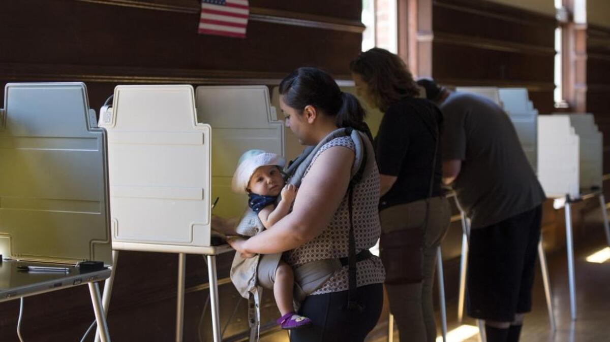 Melisa Claridad of Sacramento, casts her vote with her 13-month-old daughter, Lily Larsen, in tote, at the Clunie Community Center on Tuesday, June 7, 2016 in Sacramento.