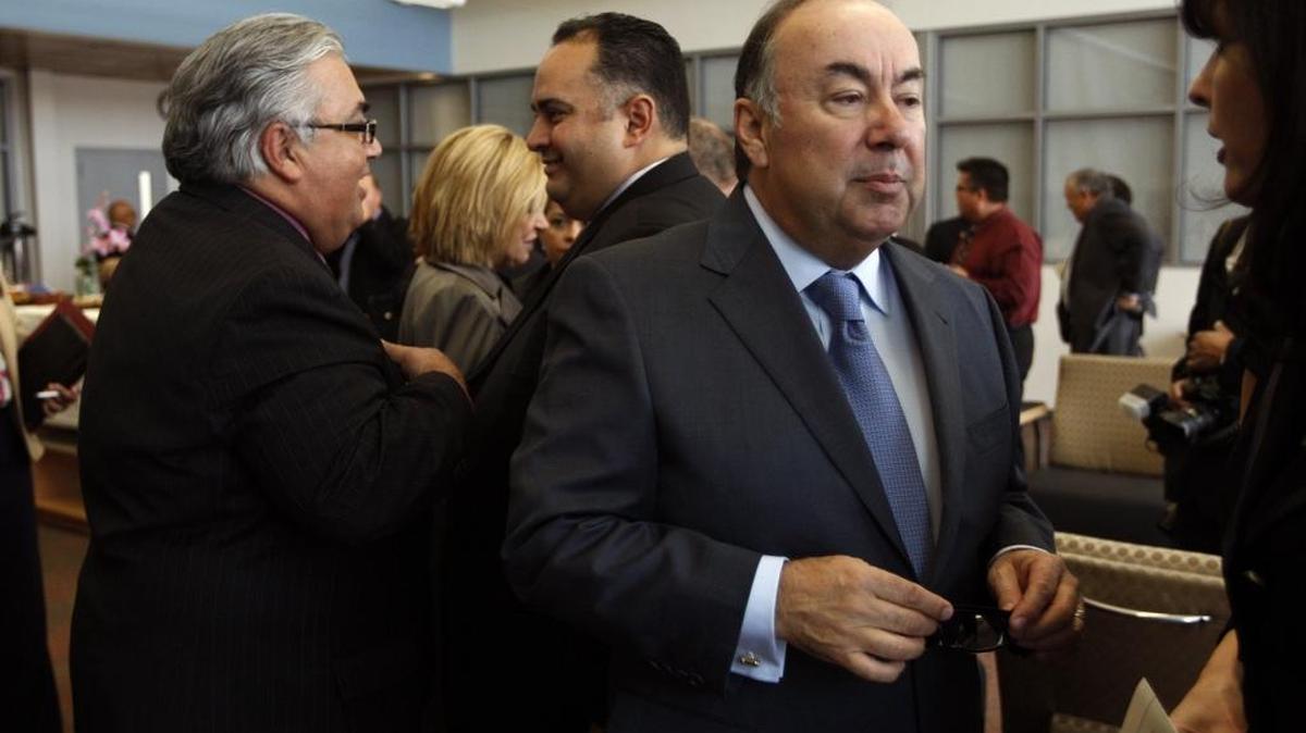 Former state assemblyman Tom Calderon talks with a friend at a memorial service for his late wife, Marcella Calderon, at the Montebello Applied Technology Center High School in Montebello on January 14, 2012.