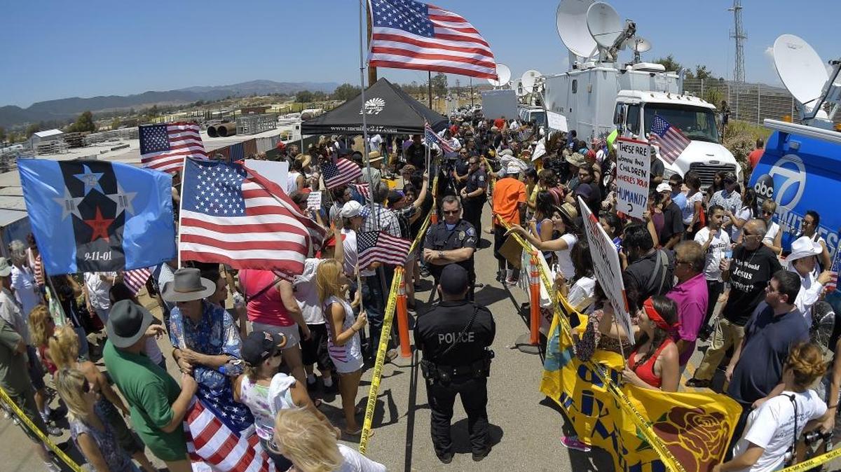 Demonstrators from opposing sides confront each other while being separated by Murrieta police officers on July 4, 2014, outside a U.S. Border Patrol station in Murrieta, Calif. Demonstrators on both sides of the immigration debate had gathered where the agency was foiled earlier this week in an attempt to bus in and process some of the immigrants who have flooded the Texas border with Mexico. Although immigration remains a hot political issue, it’s now a fairly small factor in California’s population growth.