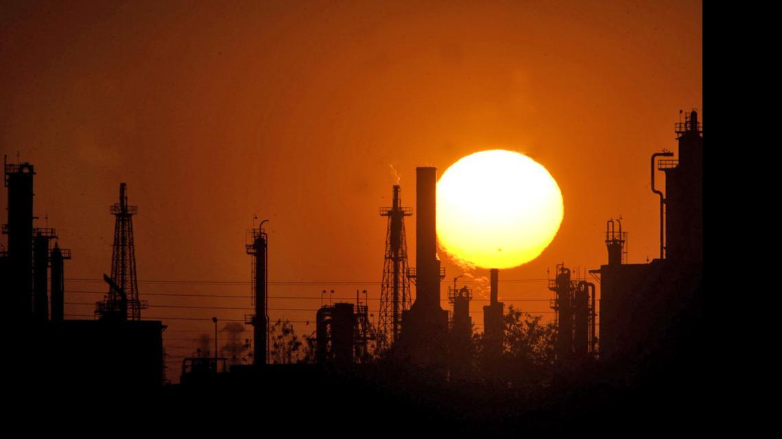 
The sun sets behind a Bakersfield oil refinery. The Senate last week passed bills seeking to cut greenhouse gas emissions and increase the state's reliance on renewable energy.
