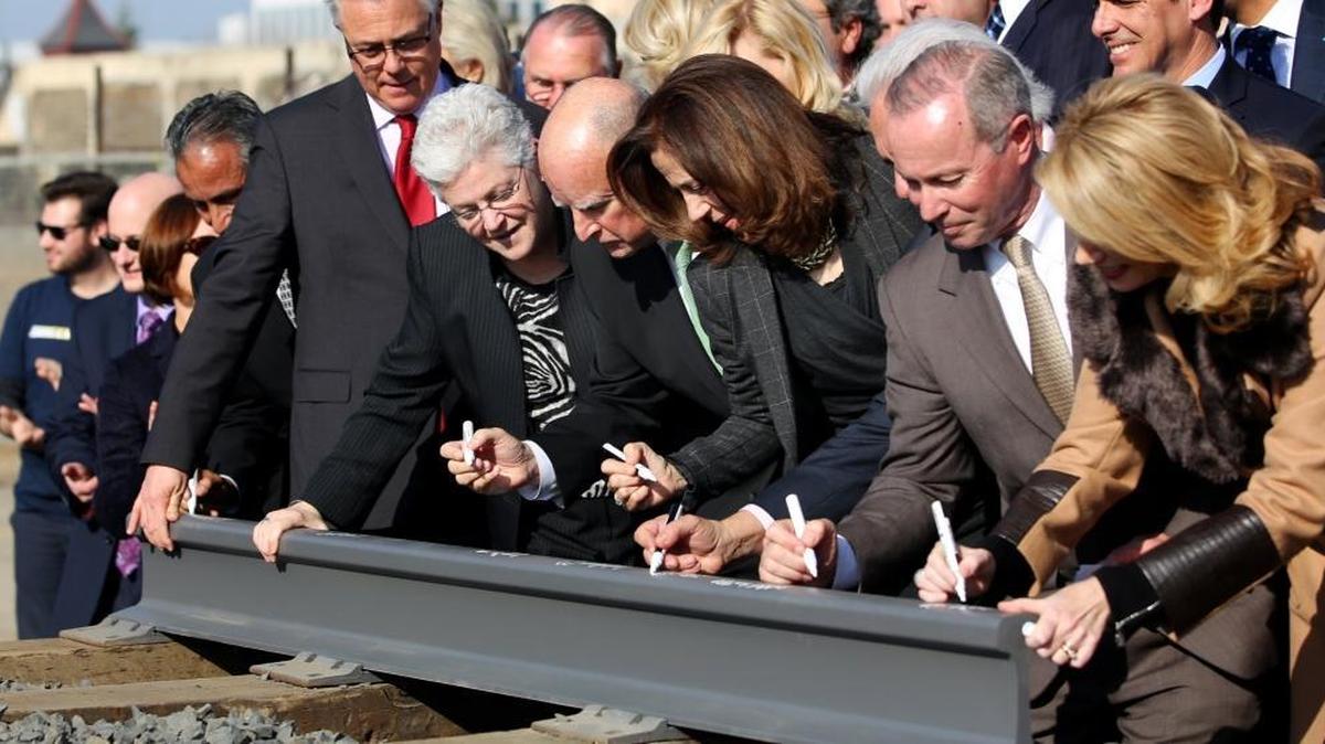 Gov. Jerry Brown his wife Anne Gust, fourth from right, sign a portion of the rail at the California High Speed Rail Authority ground breaking event as U.S. Environmental Protection Agency administrator Gina McCarthy watches, on Jan. 6, 2015 in Fresno, Calif.