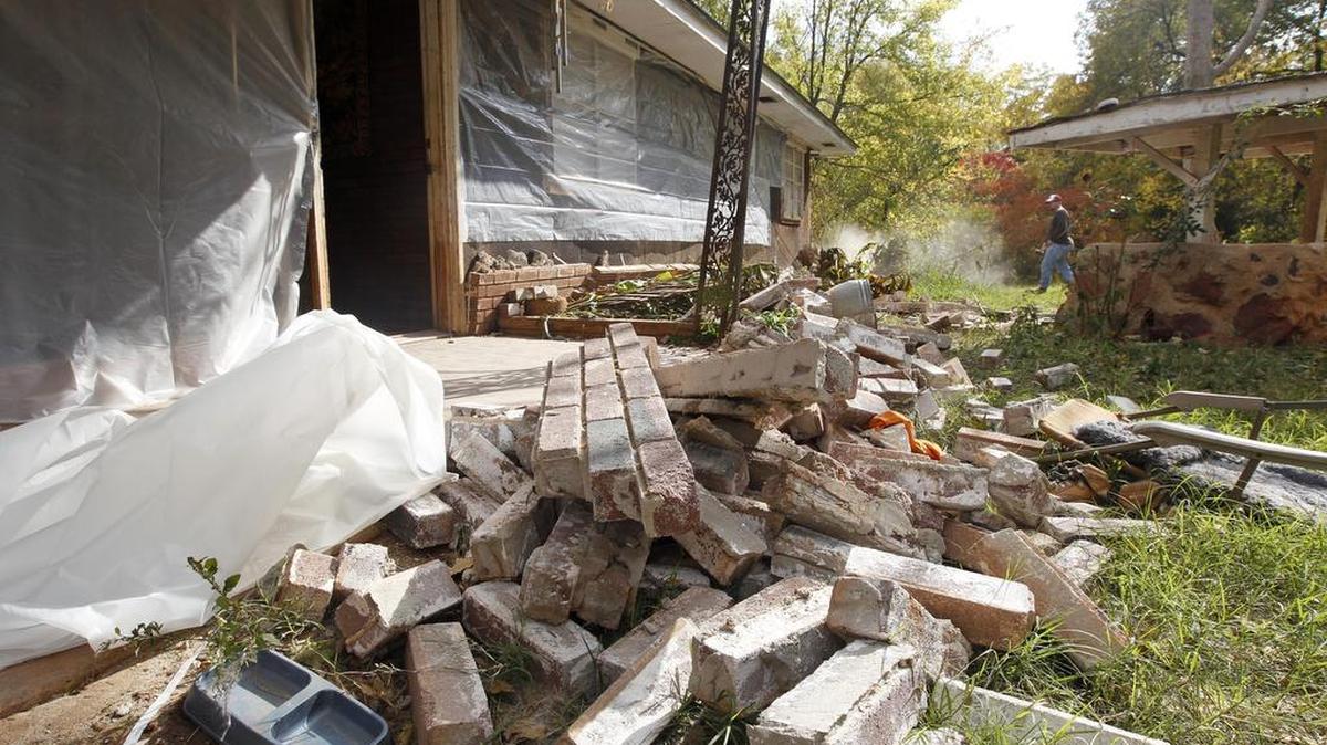 Chad Devereaux works to clear away bricks that fell from three sides of his in-laws’ home in Sparks, Okla., after two earthquakes hit the area in less than 24 hours in 2011. Caltrans experts have advised Oklahoma officials about mitigating earthquake risks.