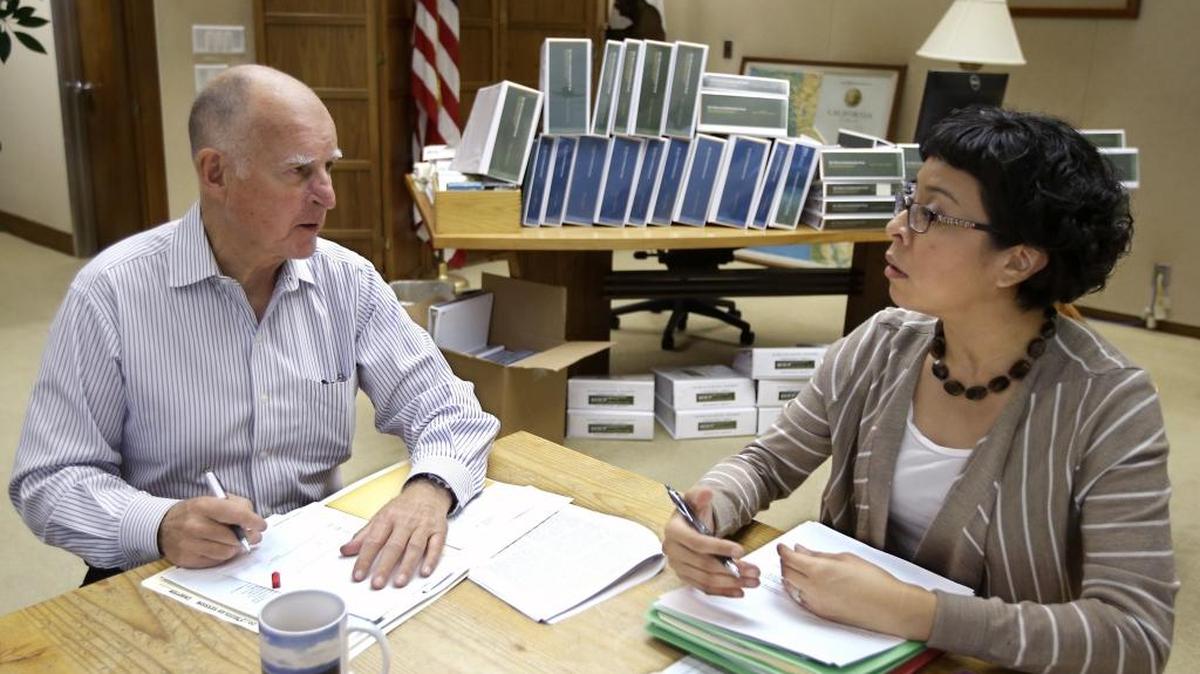 
California Gov. Jerry Brown discusses a bill he is about to sign with Garciela Castillo-Krings, his deputy legislative secretary, at his Capitol office in Sacramento, Calif., Friday Oct. 9, 2015.
