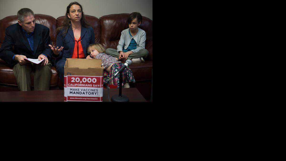 
Hannah Henry of Napa, with her children Marjorie Terrien, 2, and Helen Terrien, 10, and Carl Krawitt, deliver a box of petitions containing more than 20,000 signatures seeking to require vaccinations for most schoolkids. 
