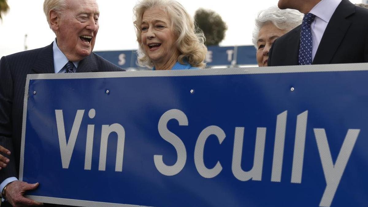 Vin Scully looks at his wife Sandra Hunt while holding a new Vin Scully Ave. sign during a ceremony held for him to proclaim the renaming of a street leading into Dodger Stadium on April 11, 2016 in Los Angeles.