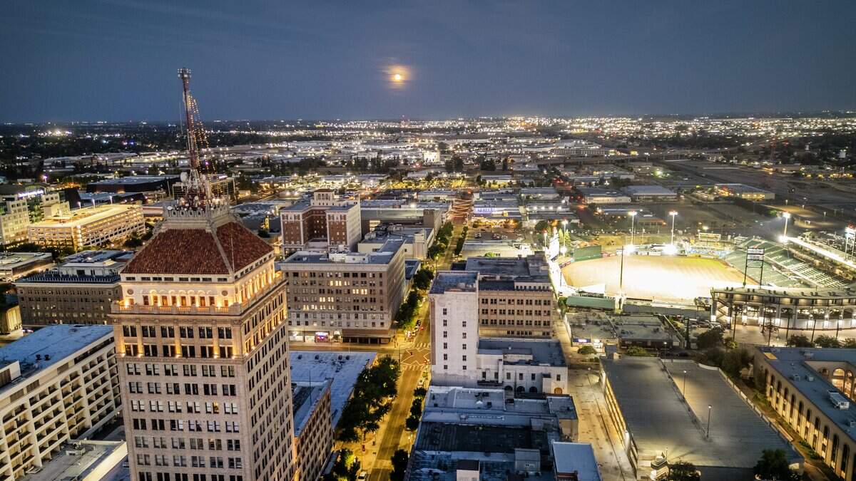 The moon rises above the downtown Fresno skyline viewed from a drone camera on Tuesday, June 10, 2025.