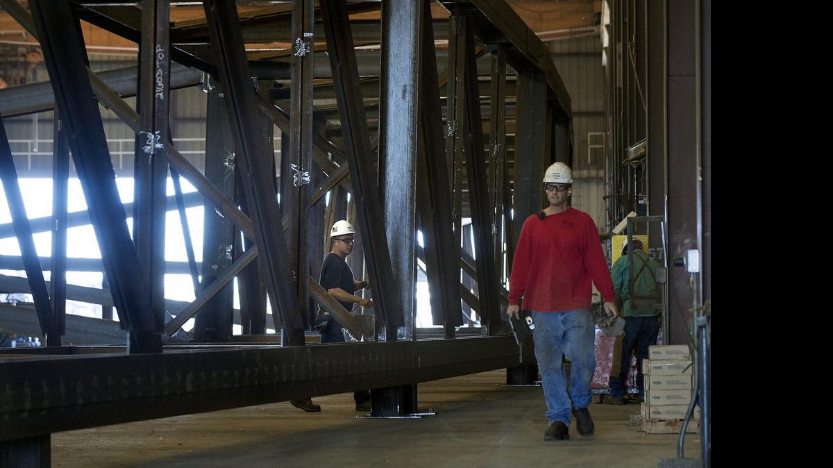
Workers walk through one of the two large trusses at Schuff Steel in Stockton on Tuesday on June 30, 2015. Schuff Steel is manufacturing the steel components being used to construct the new Golden 1 Center arena in Sacramento. Construction has one of the state’s highest rates of worker injuries and therefore worker’ compensation costs.
