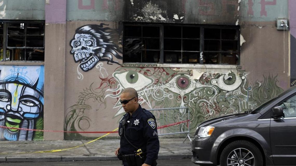 An Oakland police officer guards the area in front of the artist collective warehouse known as the Ghost Ship in the aftermath of a deadly fire in December.