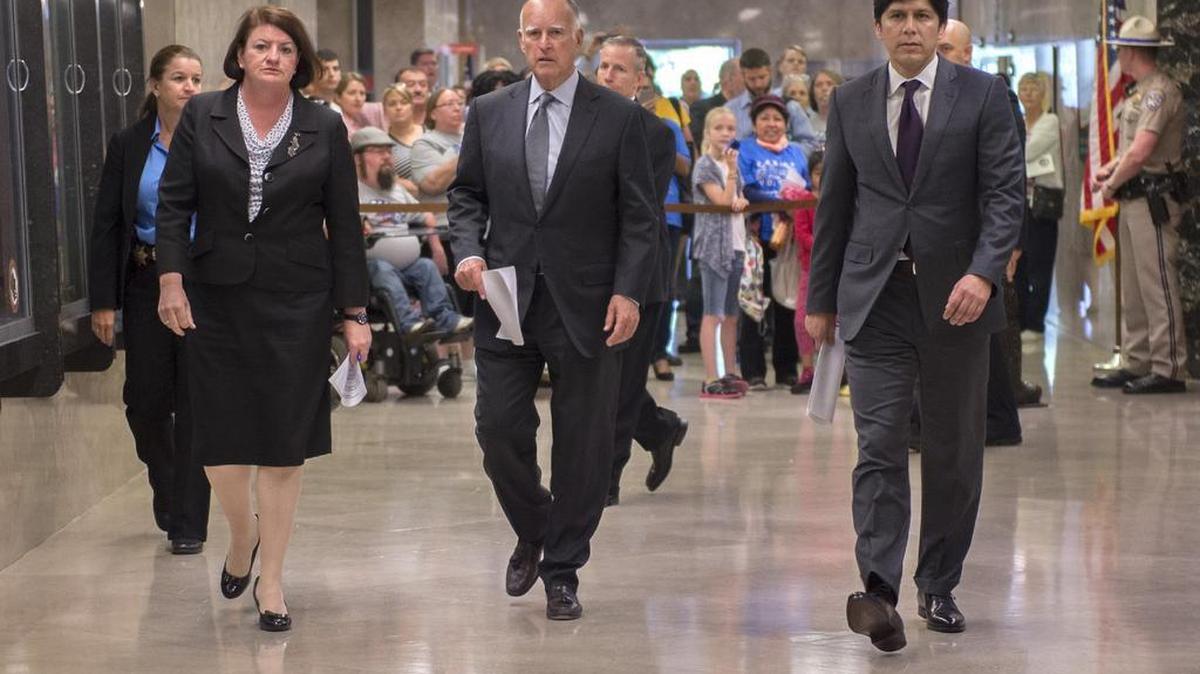 
California Gov. Jerry Brown, center, flanked by Assembly Speaker Toni Atkins, D-San Diego, left, and Senate President Pro Tem Kevin de Leon, D-Los Angeles, right, walk to a news conference to announce a budget agreement in June.
