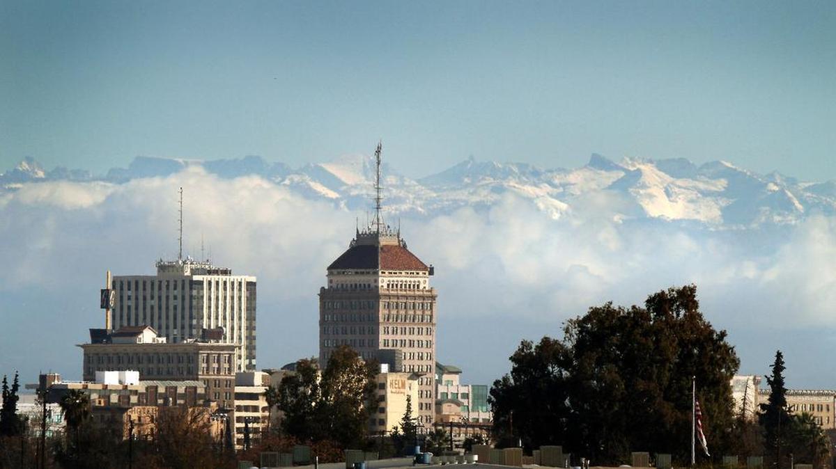 
Fresno Bee archive image of the downtown Fresno skyline seen below snow caps the Sierra Nevada mountains and clouds along the foothills on Monday, December 14, 2009.
