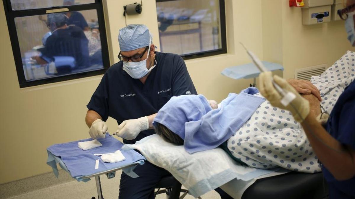 A doctor removes potentially cancerous skin cells from a patient during in Cincinnati, Jan. 13, 2014.