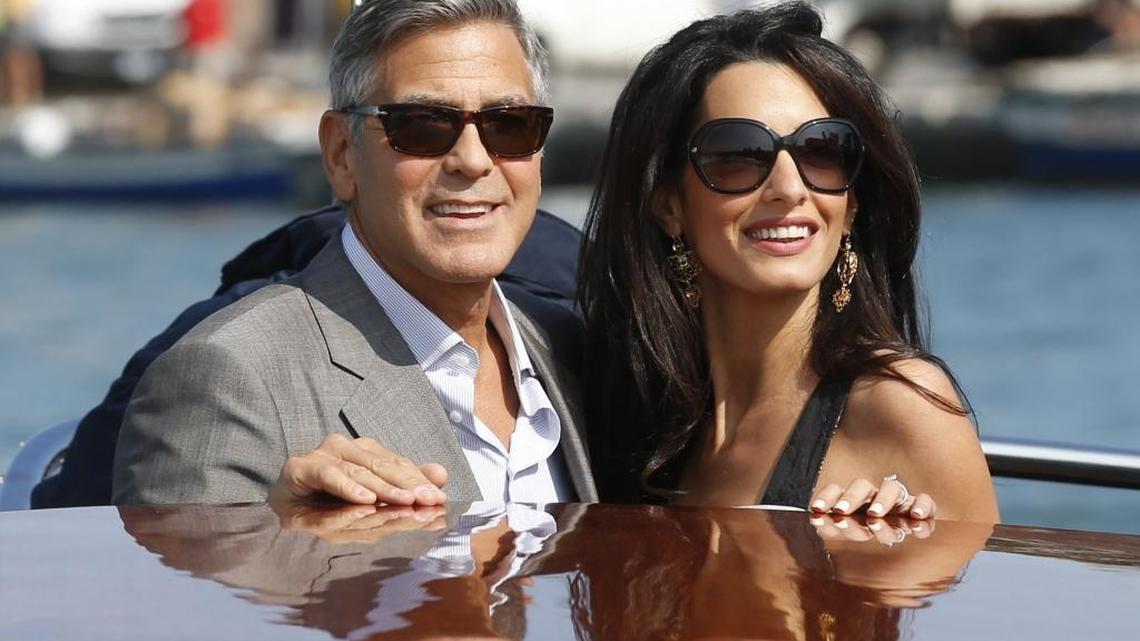 George Clooney, left, and his wife, Amal, arrive in Venice, Italy, on Sept. 26, 2014.