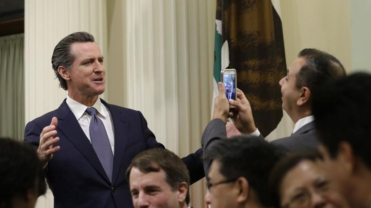 State Sen. Tony Mendoza, D-Artesia, right, takes a photo of Lt. Gov. Gavin Newsom, left, as they wait for Gov. Jerry Brown to enter the Assembly to present his annual State of the State address to a joint session of the California Legislature, Thursday, Jan. 21, 2016, in Sacramento, Calif.