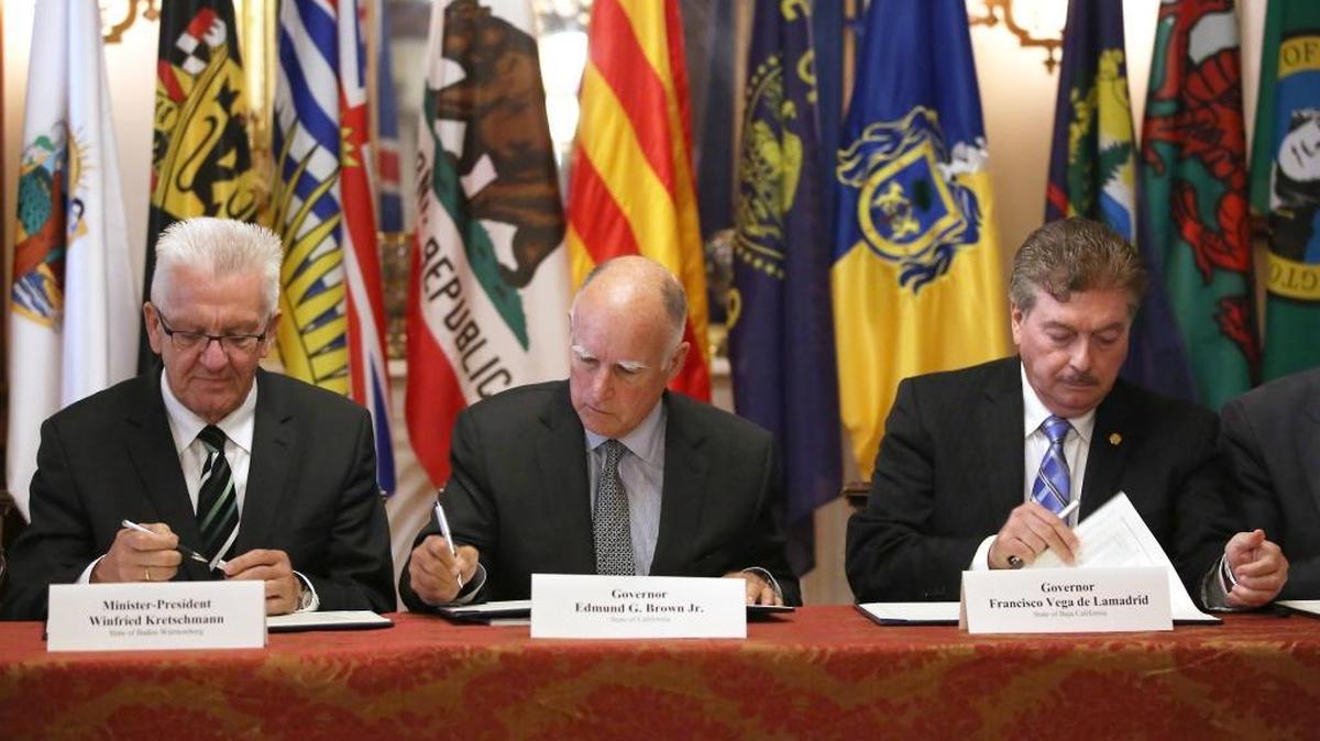 Gov. Jerry Brown, center, flanked by Baden-Wurttemberg Minister-President Winfried Kretschmann, left, of Germany, and Baja California Gov. Francisco A. Vega de Lamadrid, sign a non-binding climate change agreement in Sacramento on May 19, 2015.
