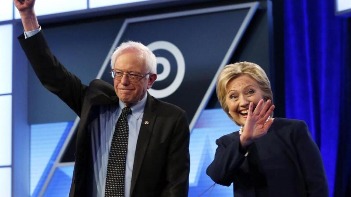 In this March 9, 2016, photo, Democratic presidential candidates, Hillary Clinton and Sen. Bernie Sanders, I-Vt., stand together before the start of the Univision, Washington Post Democratic presidential debate at Miami-Dade College in Miami.