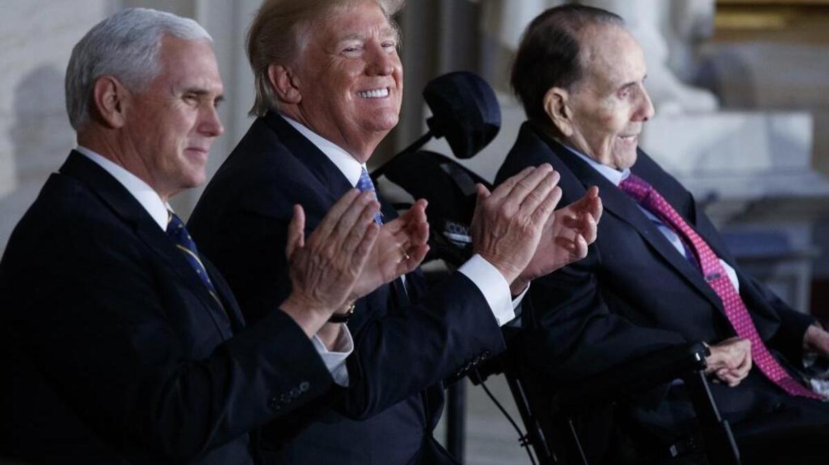 Vice President Mike Pence, left, sits with President Donald Trump, center, during a Congressional Gold Medal ceremony honoring former Sen. Bob Dole on Capitol Hill, Wednesday, Jan. 17, 2018, in Washington.