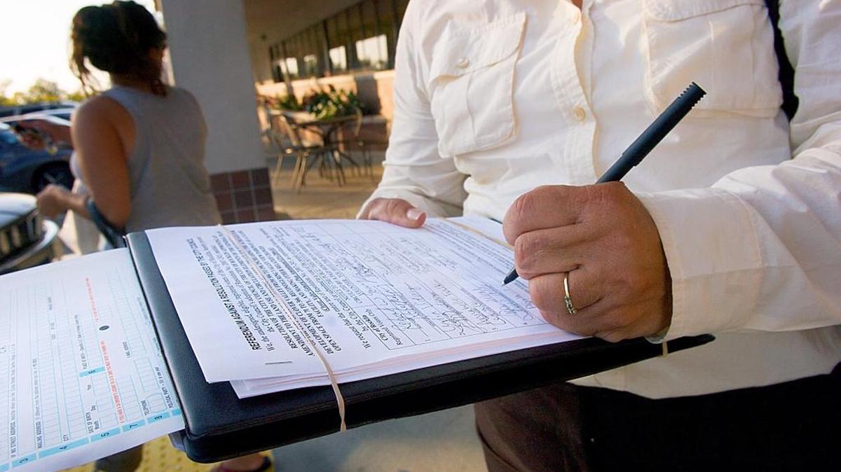 New caption: A Rocklin voter signs a petition in 2007 to help qualify a local referendum. Various campaigns are hurrying to gather signatures to qualify November 2016 ballot measures.