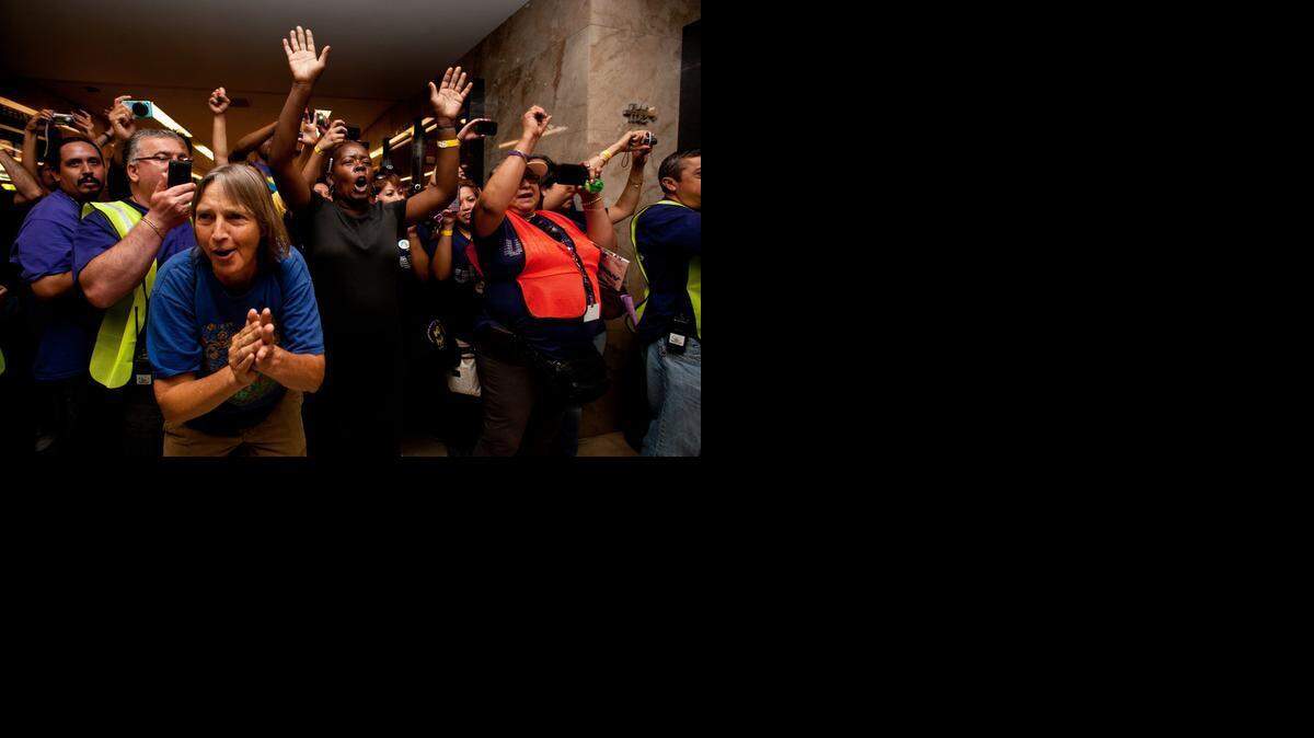 
Union members and supporters cheer as union members are arrested outside the governor’s office at the state Capitol in 2012. Demonstrators protested budget cuts for in-home services to the elderly and disabled.
