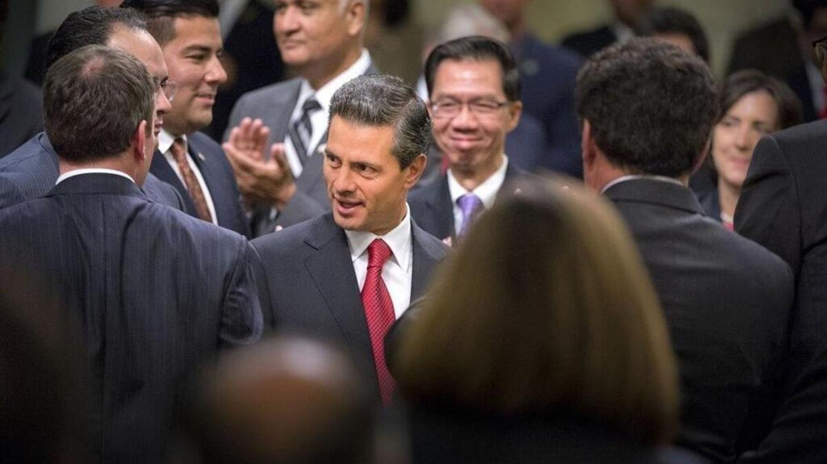 Mexican President Enrique Peña Nieto is greeted by lawmakers during a joint meeting of the Legislature on Aug. 26, 2014.