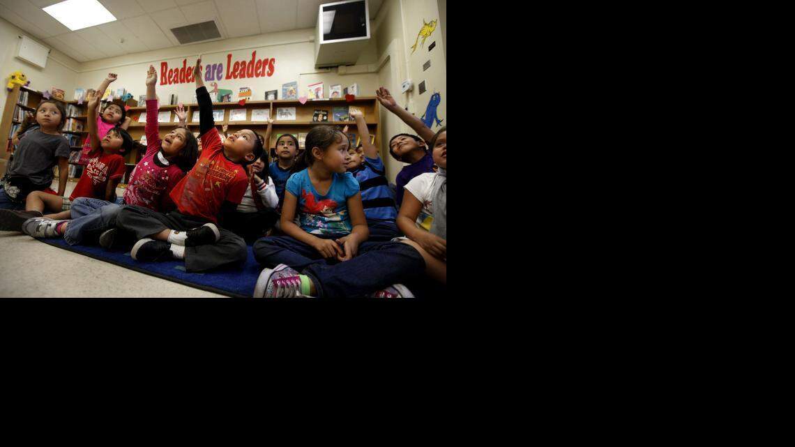 
First graders raise their hands to answer a question after library aide Cindy Ramirez reads the book "Abe Lincoln's Hat" on Feb. 13, 2014 at San Pedro Elementary School in Los Angeles. 
