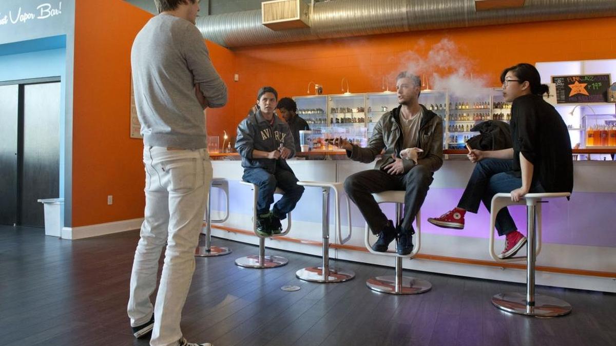
Cory Parravano, left, manager of The Vapor Spot on J Street in midtown Sacramento talks to customers who smoke e-cigarettes on Wednesday, Jan. 27, 2015. California health officials say electronic cigarettes are a health threat that should be strictly regulated like tobacco products.
