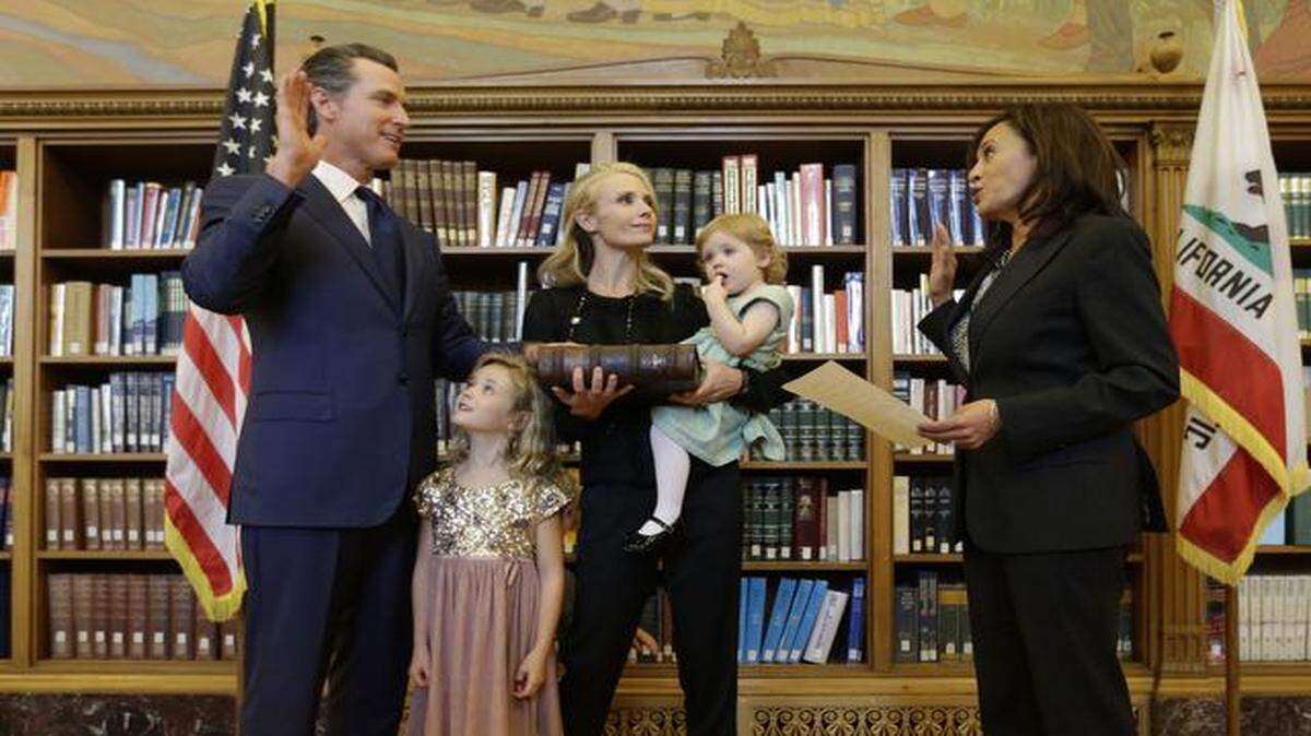 
Montana Newsom, 5, second from left, looks up at her father, Lt. Gov. Gavin Newsom, as he takes the oath of office from Attorney General Kamala Harris, right, during an inauguration ceremony in Sacramento on Monday.
