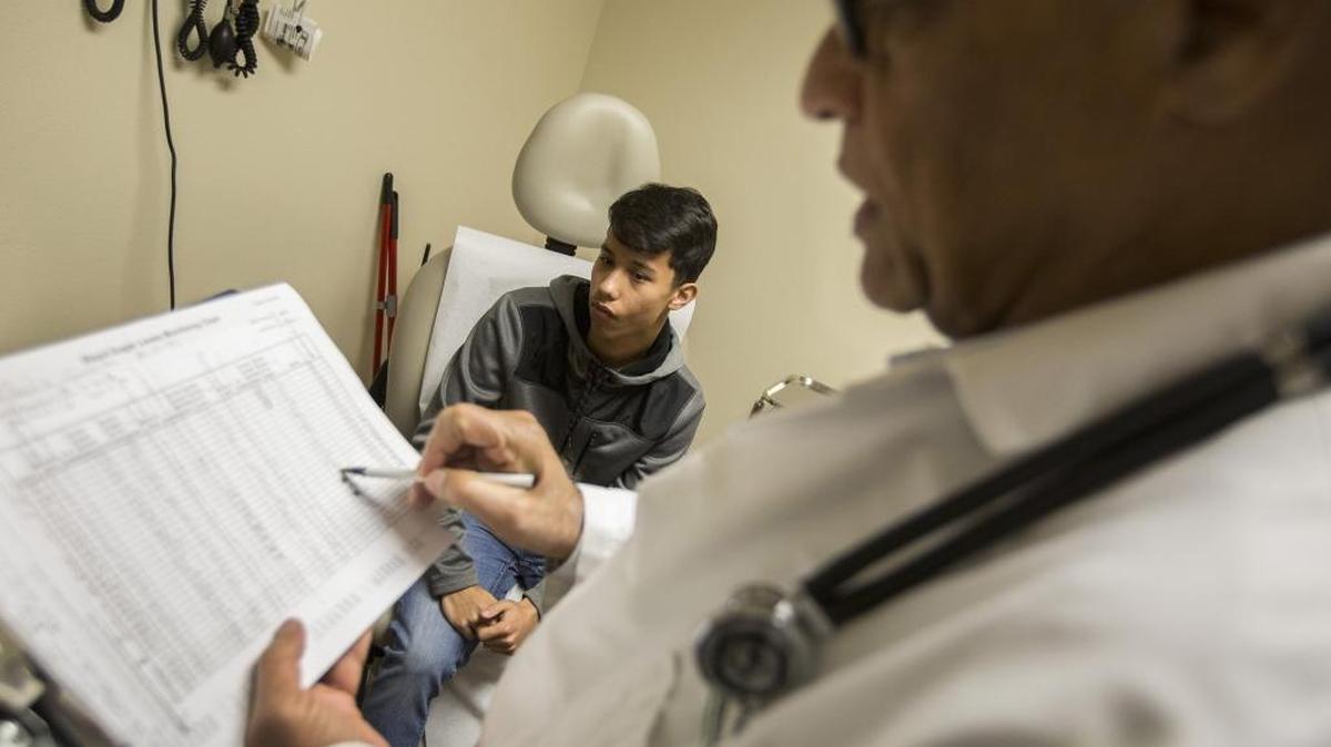 Dr. Karunyan Arulanantham, right, talks with patient Saul Gonzalez, 17, left, at the Antelope Valley Community Clinic on Feb. 6, 2017, in Lancaster, Calif.