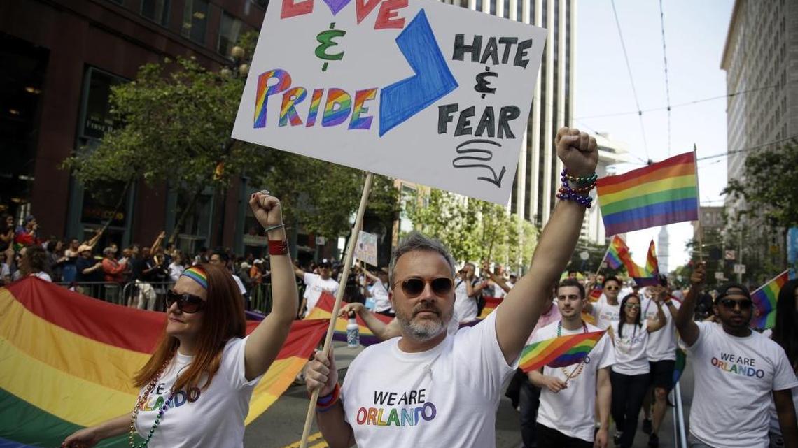 Todd Elmer, center, and, Rachel Payne, left, march during the San Francisco Gay Pride parade Sunday, June 26, 2016, in San Francisco.