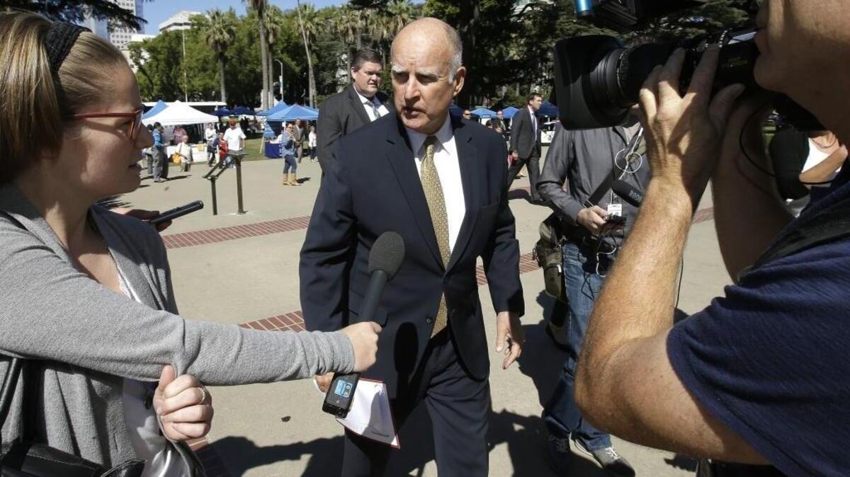 Gov. Jerry Brown talks to reporters as he walks to the Capitol. Friday, Sept. 23, 2016, in Sacramento, Calif.