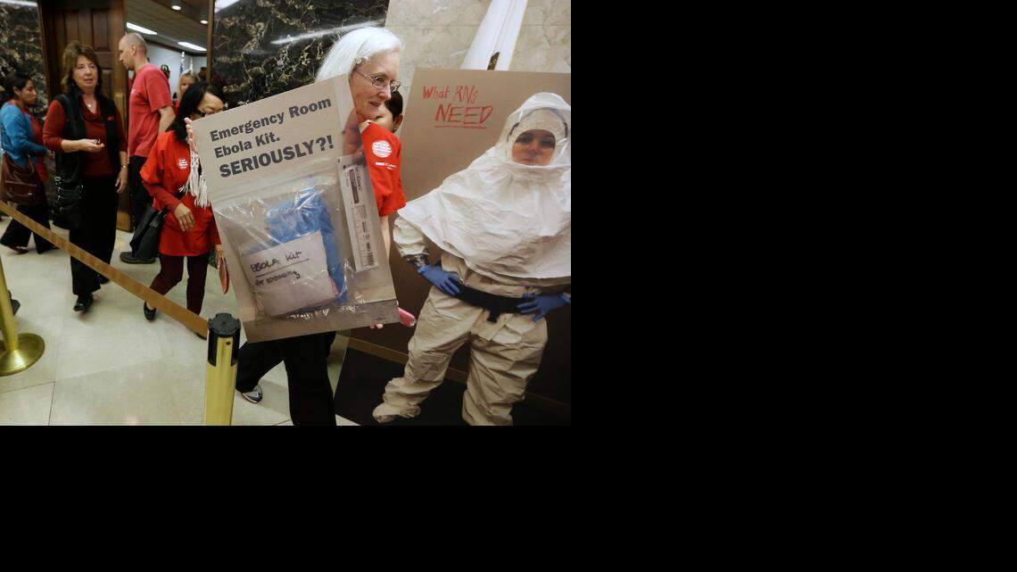 
Kathryn Williams carries a poster Tuesday as she and other members of the California Nurses Association leave a meeting with Gov. Jerry Brown to discuss the Ebola preparedness in the state. The Brown administration has not issued any mandates beyond new protective guidelines for medical workers, recommended by the Centers for Disease Control and Prevention. 
