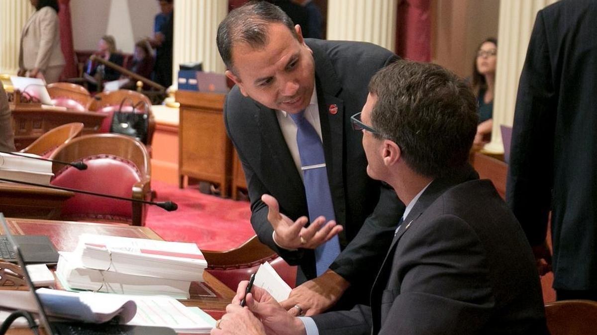 State Sen. Tony Mendoza, D-Artesia, left, talks with Sen. Ted Gaines, R-El Dorado Hills, during the Senate session on May 30, 2017.